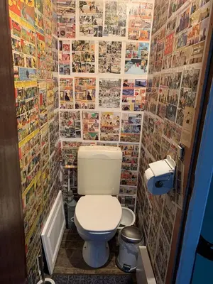 a bathroom with a toilet and a wall of photos at Au 81 in Liège
