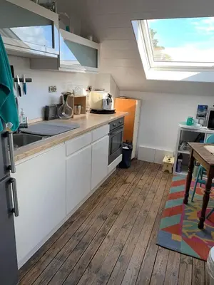 a kitchen with white cabinets and a skylight at Au 81 in Liège