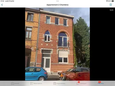 a blue car parked in front of a brick building at Au 81 in Liège