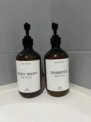 two bottles of soap sitting on a shelf at Appartement Verviers in Verviers