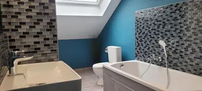a bathroom with a tub and a toilet and blue walls at Gîte de Trasenster in Trooz