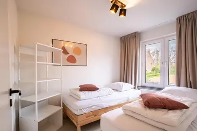 a bedroom with two beds and a book shelf at Maas Suites - The River House with private sauna in Lanaken