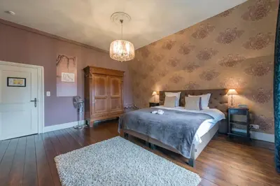 a bedroom with a bed and a chandelier at Boutique Hotel Huys van Steyns in Tongeren