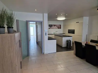 a large kitchen and living room with a counter top at Tuinappartement van 175m² en 4 slaapkamers in Hasselt