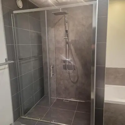 a shower with a glass door in a bathroom at Tuinappartement van 175m² en 4 slaapkamers in Hasselt