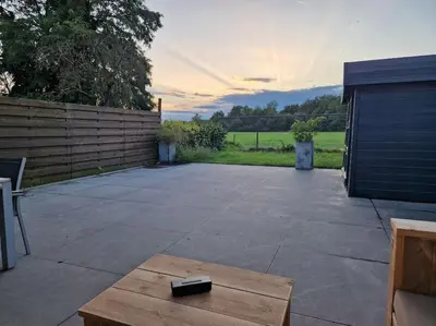 a remote control sitting on a table on a patio at Tuinappartement van 175m² en 4 slaapkamers in Hasselt