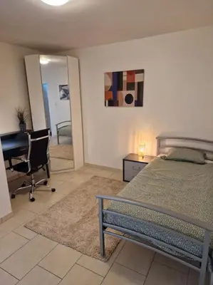 a bedroom with a bed and a desk and a desk at Tuinappartement van 175m² en 4 slaapkamers in Hasselt