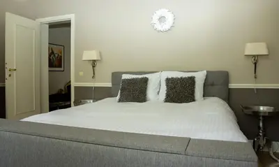 a bedroom with a bed with white sheets and pillows at B&B Huis Spaas in Pelt