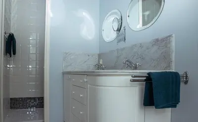 a bathroom with a sink and two mirrors at B&B Huis Spaas in Pelt