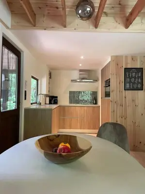 a bowl of fruit sitting on a table in a kitchen at Prachtige chalet in het bos met sauna! in Lanaken