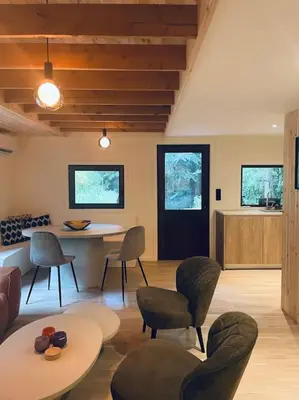 a living room with a table and chairs at Prachtige chalet in het bos met sauna! in Lanaken