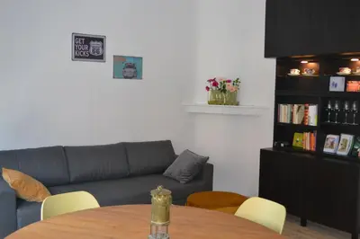 a living room with a table and a couch at De zwarte deur in Genk