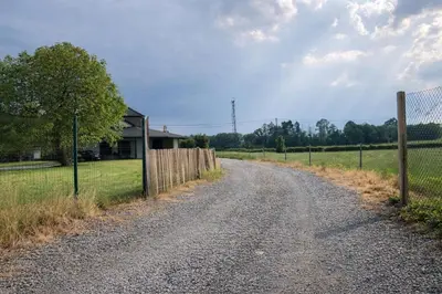 a dirt road next to a fence and a house at Spa-Francorchamps - Jahlay - Maison 6p de caractère - Famille - Ardennes - Nature in Jalhay