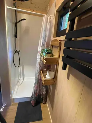 a bathroom with a shower and a shower curtain at Pipowagen de Pauw in de bossen van Belgisch Limburg nabij Maastricht in Lanaken