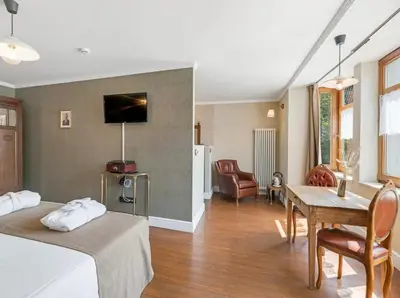 a bedroom with a bed and a table and a couch at Café René Borgloon in Borgloon