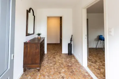 a hallway with a wooden dresser and a mirror at Aan de bosrand in Oudsbergen