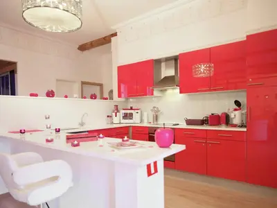 a red kitchen with a white counter and red cabinets at Cozy Stay with Pool & Nature in Ensival