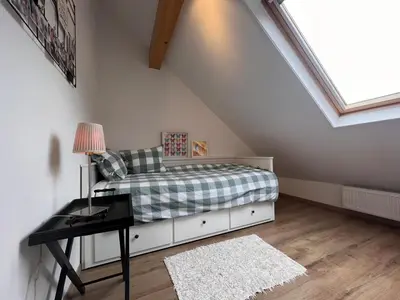 a bedroom with a bed and a desk in a attic at De Lelie in Rekem