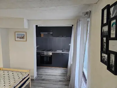 a room with a kitchen with a stove and a window at Logment Outremeuse 1D in Liège