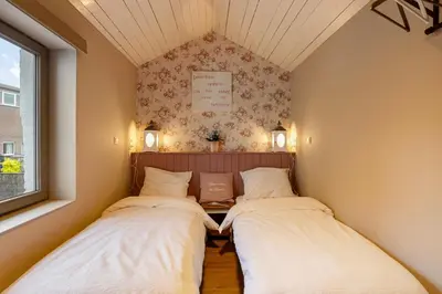 two beds in a small room with a window at Bibi Tongeren in Tongeren