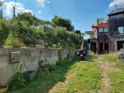a garden with a motorcycle parked next to a wall at Gee is Sharing her home in Liège