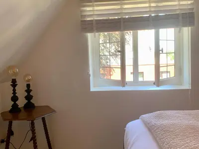 a bedroom with a bed and a window at Zolder appartement Le Grenier in Dilsen-Stokkem