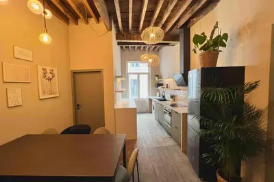 a kitchen and dining room with a table and a refrigerator at Maison avec 4 suites & Rooftop en plein centre ville - Place Saint Paul in Liège