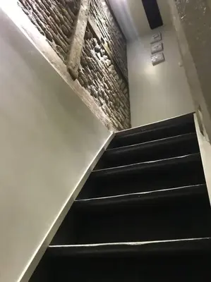an escalator in a building with black stairs at Petite maison Liégeoise «la cabane de Liège» in Liège