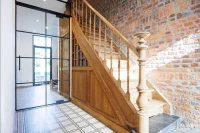 an open hallway with a brick wall and stairs at Li Mohone in Donceel