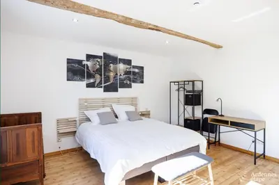 a bedroom with a white bed and a desk at Li Mohone in Donceel