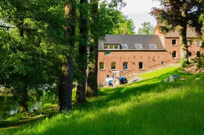 a house with a tractor parked in front of a grass field at Domaine des Arches in Soumagne
