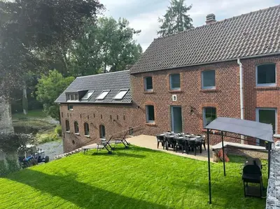 a large brick building with a table in the yard at Domaine des Arches in Soumagne