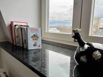 a shelf with books and a chicken next to a window at Le Neuvice - Place du marché, Quais, Bueren in Liège