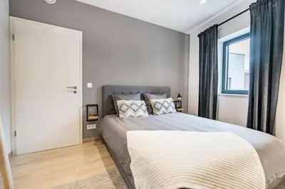 a bedroom with a large bed and a window at L'appart Léon, avec parking gratuit in Liège