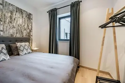 a bedroom with a large bed and a window at L'appart Léon, avec parking gratuit in Liège