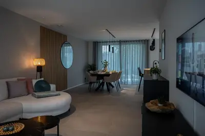a living room with a couch and a dining room at NIEUW - De Grenspaal WEST 6P 5 min Maastricht - Sauna - Laadpaal in Riemst