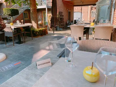 a table with two wine glasses and a lemon on it at Hoeve de Sterappel in Tongeren