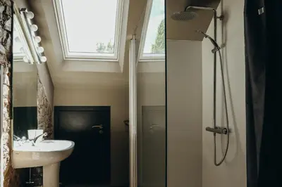 a bathroom with a sink and a shower with a window at La Terrasse du Pré by WelcHome in Verviers