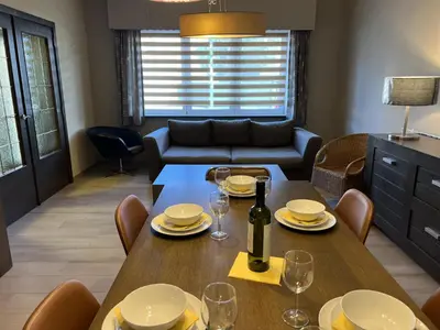 a dining room with a table with glasses and a bottle of wine at 8P 4B Beautiful house with 4 bedrooms in Hees in Bilzen