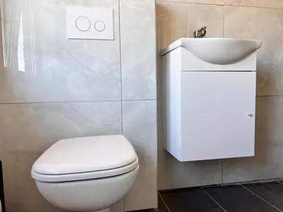 a bathroom with a white toilet and a sink at 8P 4B Beautiful house with 4 bedrooms in Hees in Bilzen