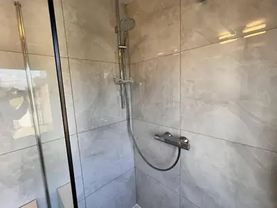a shower with a glass door in a bathroom at 8P 4B Beautiful house with 4 bedrooms in Hees in Bilzen