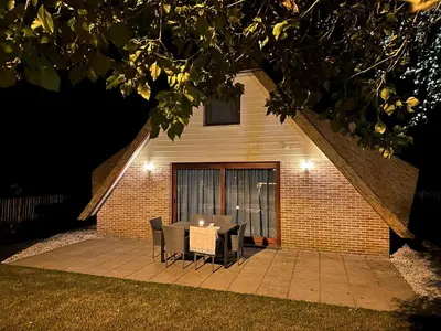 a table and chairs on a patio at night at Vakantiewoning Waag in Rekem