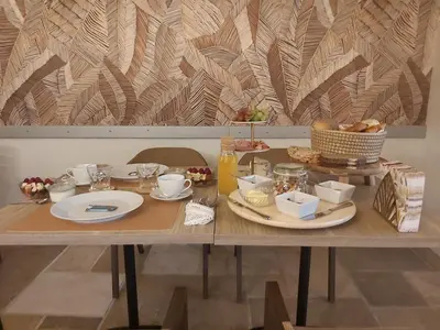 a wooden table with plates of food on it at B&B Asmara in Maasmechelen