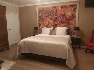 a bedroom with a large bed with a painting on the wall at B&B Asmara in Maasmechelen