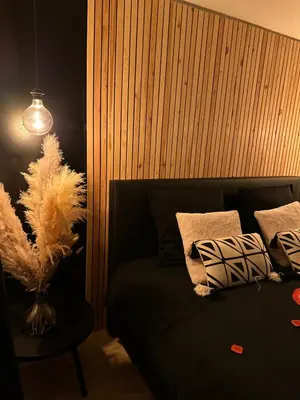 a bedroom with a bed and a table with pillows at Suite Marie in Verviers