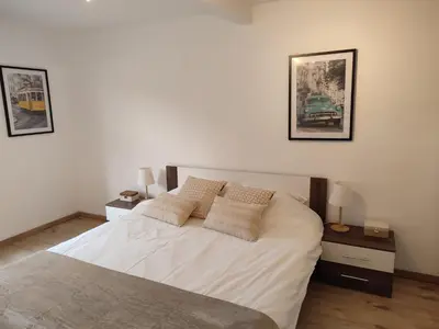 a bedroom with a large white bed with two night stands at Le Gîte du Moulin - Modernity & Elegance - jacuzzi in Oupeye