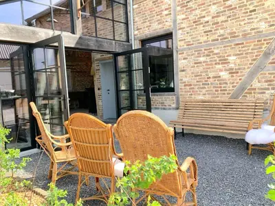 a group of chairs and a bench in front of a building at Maison Cuberdon in Riemst