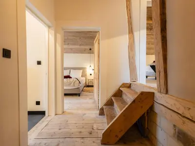 a hallway with a wooden staircase in a room at Maison Cuberdon in Riemst