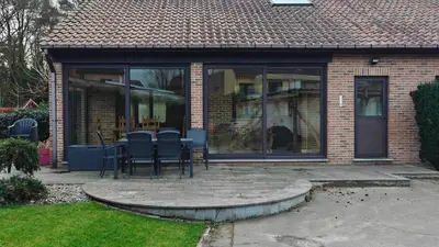 a patio with chairs and a table in a house at Brelaarheide in Houthalen-Helchteren