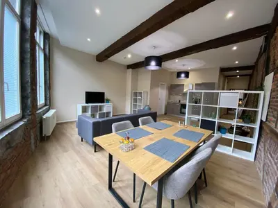 a dining room with a table and a couch at The Mind Box 2 in Liège